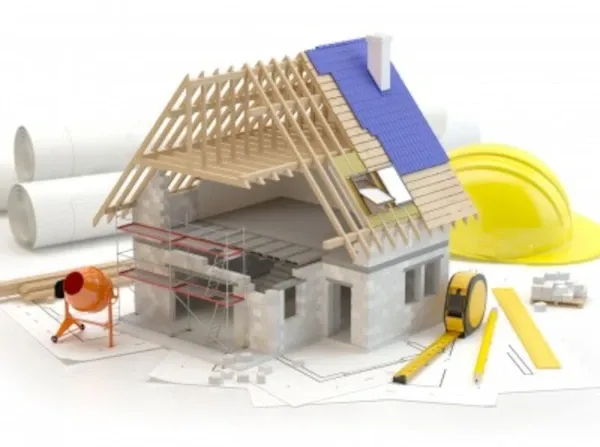 grafika przedstawia dom jednorodzinny podczas budowy, częściowo zabudowany dach, przy domu : betoniarka, kasak, miarka, linijka, ołówek, plan domu